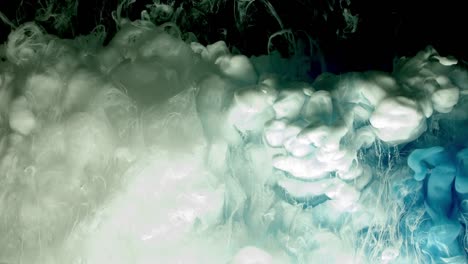 Blue-and-white-acrylic-paint-cloud-spraying-in-water-on-black-background.