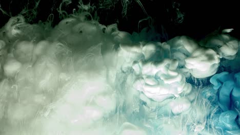 Blue-and-white-acrylic-paint-cloud-spraying-in-water-on-black-background.