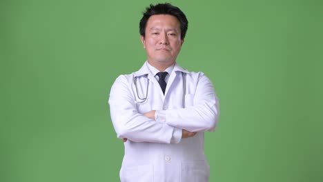 Mature-Japanese-man-doctor-against-green-background