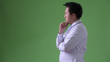 Mature-Japanese-man-doctor-against-green-background