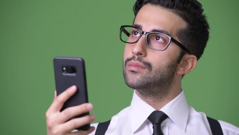 Junge-hübsche-bärtigen-persische-Geschäftsmann-vor-grünem-Hintergrund