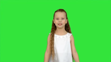 Cute-little-girl-singing-a-song-and-dancing-on-a-Green-Screen,-Chroma-Key