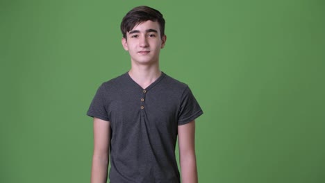 Young-handsome-Iranian-teenage-boy-against-green-background