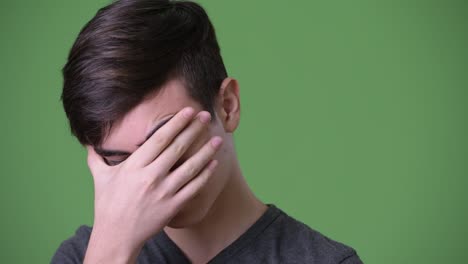 Young-handsome-Iranian-teenage-boy-against-green-background