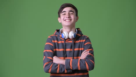 Young-handsome-Iranian-teenage-boy-against-green-background