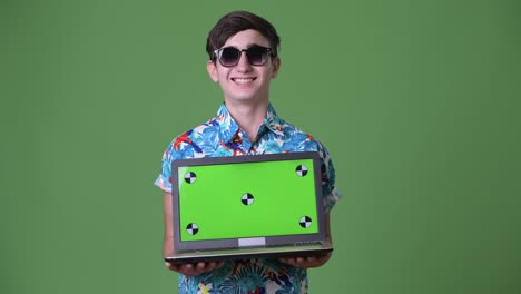 Young-handsome-Iranian-teenage-boy-ready-for-vacation-against-green-background