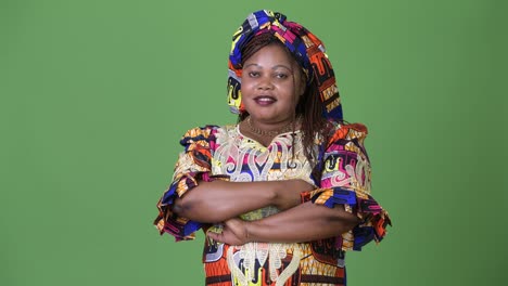 Schöne-afrikanische-Frau-in-traditioneller-Kleidung-vor-grünem-Hintergrund-mit-Übergewicht