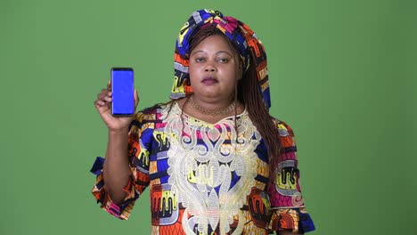 Overweight-beautiful-African-woman-wearing-traditional-clothing-against-green-background