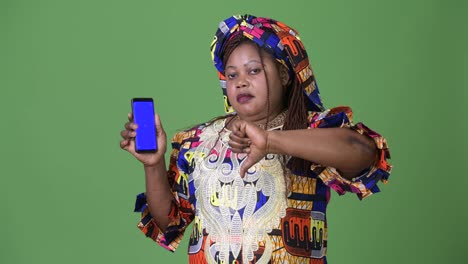 Overweight-beautiful-African-woman-wearing-traditional-clothing-against-green-background