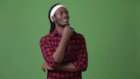 Young-handsome-African-man-with-dreadlocks-against-green-background