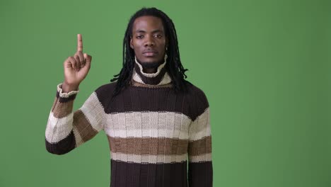 Young-handsome-African-man-with-dreadlocks-against-green-background