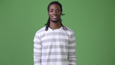 Young-handsome-African-man-with-dreadlocks-against-green-background