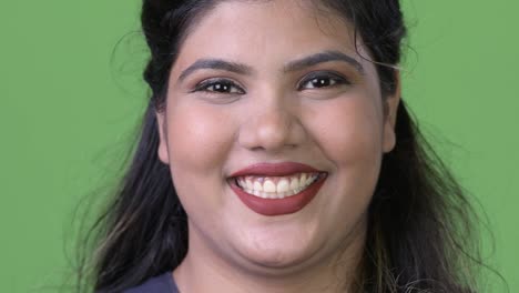 Young-overweight-beautiful-Indian-businesswoman-against-green-background