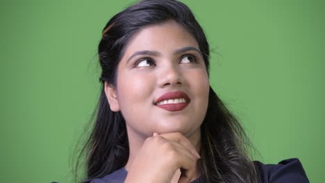 Young-overweight-beautiful-Indian-businesswoman-against-green-background