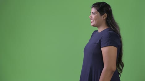 Young-overweight-beautiful-Indian-businesswoman-against-green-background