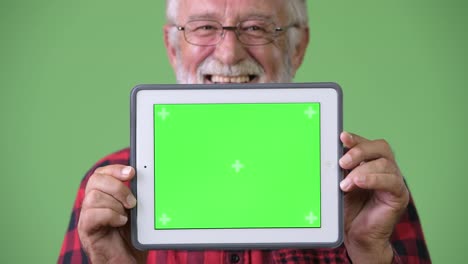 Handsome-senior-bearded-man-against-green-background