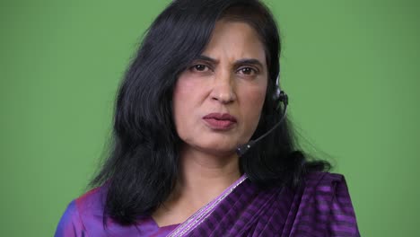 Close-up-shot-of-mature-beautiful-Indian-woman-as-call-center-representative-talking-on-headset