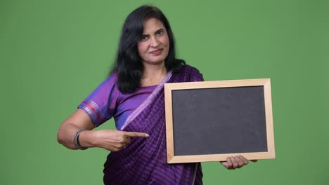 Mature-beautiful-Indian-woman-pointing-to-blackboard