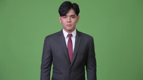 Junge-hübsche-asiatische-Geschäftsmann-zeigt-Mittelfinger