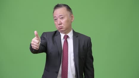 Mature-Japanese-businessman-giving-thumbs-up