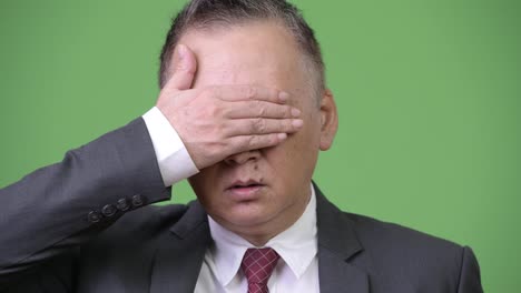 Mature-Japanese-businessman-covering-eyes-as-three-wise-monkeys-concept