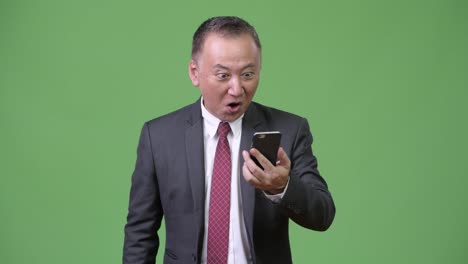 Mature-Japanese-businessman-using-phone