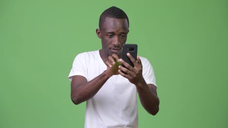 Joven-africana-mirando-sorprendido-mientras-usa-el-teléfono