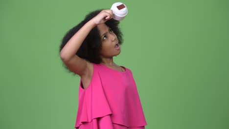 Young-cute-African-girl-with-Afro-hair-holding-empty-coffee-cup-upside-down