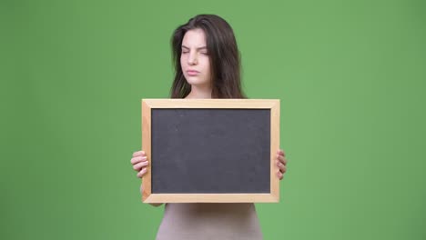 Young-beautiful-woman-nodding-no-while-holding-blackboard