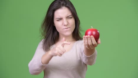 Mujer-hermosa-joven-manteniendo-apple-y-dar-pulgares-para-arriba