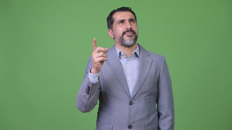 Handsome-Persian-bearded-businessman-pointing-finger-up