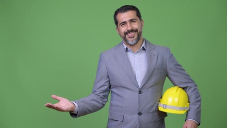 Gut-aussehend-persischen-bärtigen-Geschäftsmann-als-Ingenieur-etwas-zeigen