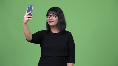 Beautiful-Asian-businesswoman-taking-selfie