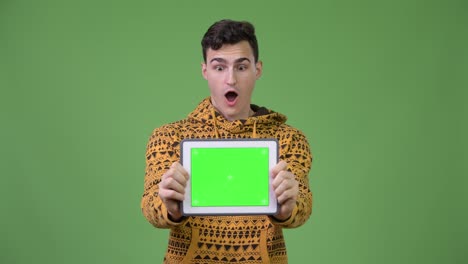 Young-handsome-man-showing-digital-tablet-and-looking-surprised
