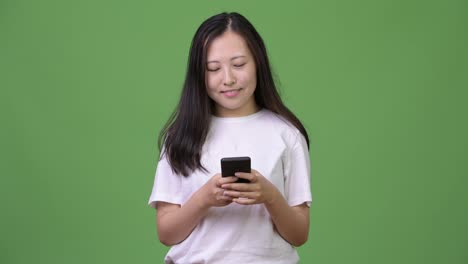 Young-Asian-woman-thinking-while-using-phone