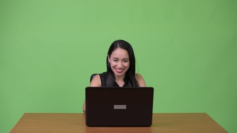 Young-Asian-businesswoman-using-laptop-with-young-man-getting-angry