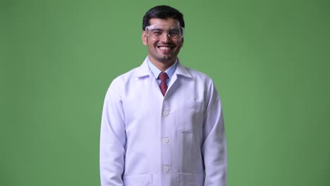 Young-happy-Persian-man-doctor-wearing-protective-glasses