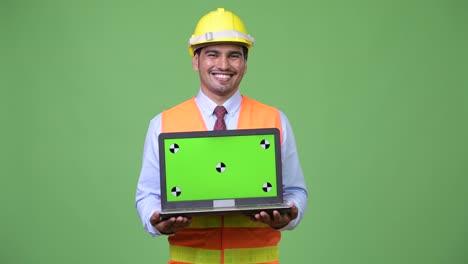 Young-handsome-Persian-man-construction-worker-showing-laptop