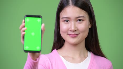 Junge-schöne-asiatische-Frau-mit-Telefon