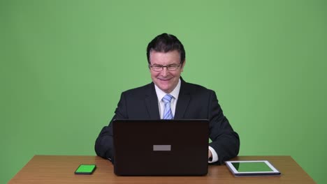 Senior-handsome-businessman-using-laptop-and-getting-good-news
