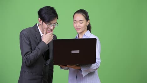 Young-Asian-business-couple-using-laptop-together