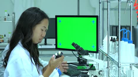 Scientist-working-in-modern-laboratory-or-medical-center.-Background-monitor-green-screen.-Concept-of-science,-testing-development-and-lab-industry.