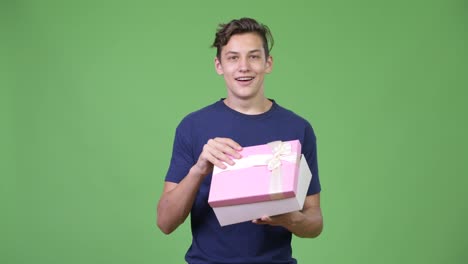 Joven-guapo-adolescente-abriendo-la-caja-de-regalo
