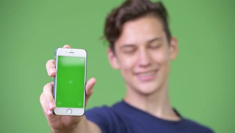 Young-handsome-teenage-boy-showing-phone