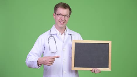 Man-Doctor-Holding-Empty-Blackboard-With-Copyspace