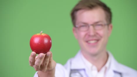 Retrato-de-joven-hombre-Doctor-Holding-rojo-manzana