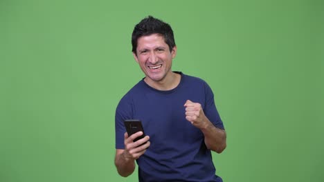 Hispanic-man-using-phone-and-getting-good-news