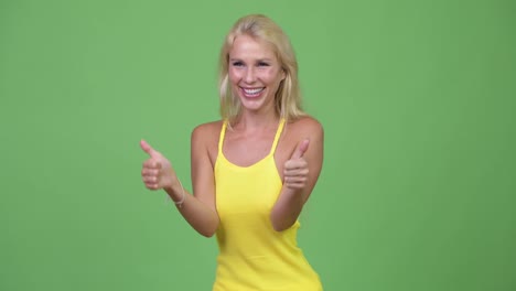 Young-happy-beautiful-blonde-woman-giving-thumbs-up-while-looking-excited