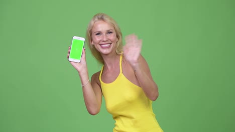 Young-happy-beautiful-blonde-woman-video-calling-and-showing-phone