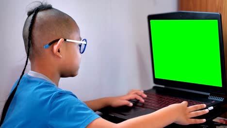 Asiaten-Knabe-Laptop-Computer-und-green-Screen-spielen.-Glückliche-Kinder-spielen-Computer-zu-Hause-genießen.